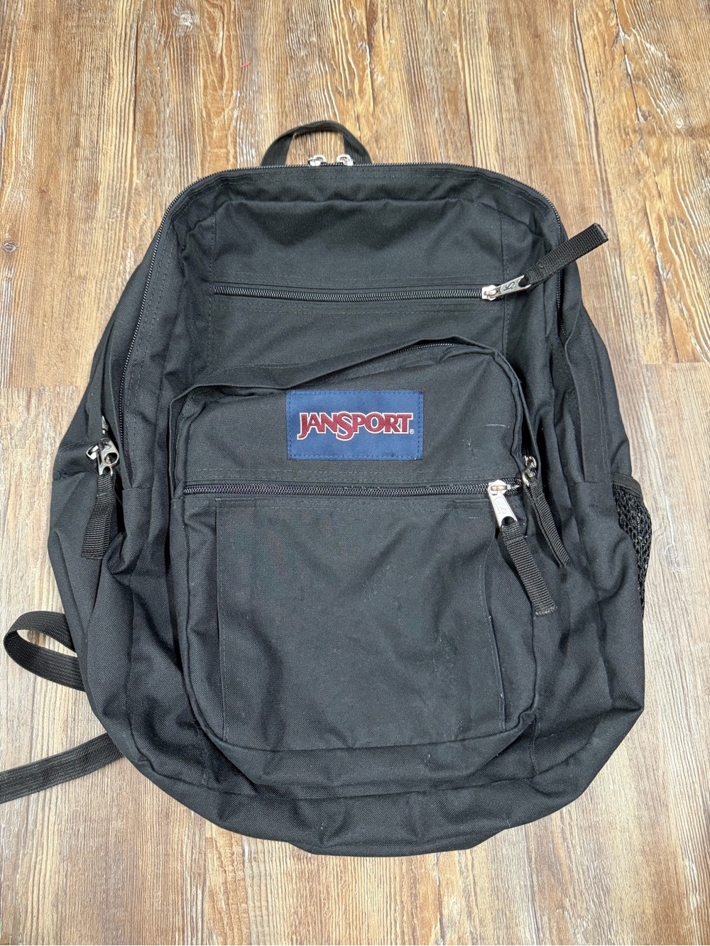 Black Jansport backpack with multiple pockets one of the zippers only zips one w